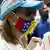 Una mujer con gafas y mascarilla de la bandera de Venezuela particpa en una protesta.