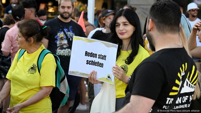 Manifestante de Dortmund sosteniendo un cartel que decía hablar en lugar de disparar