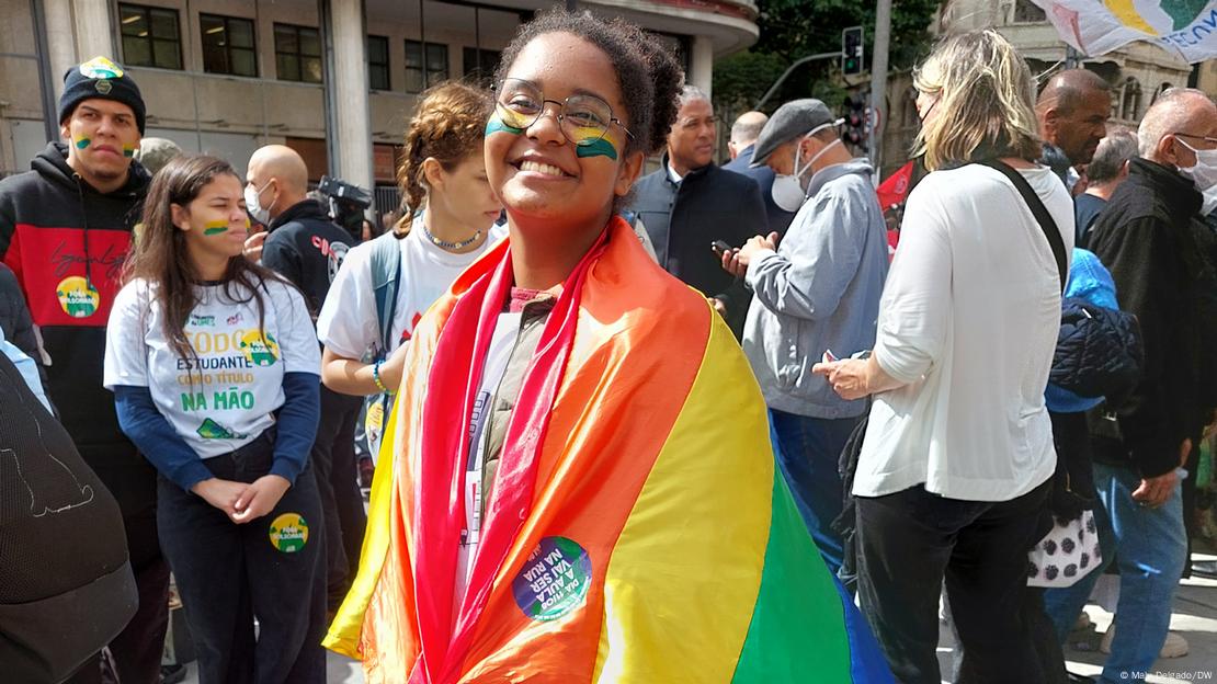 Estudante enrolada em uma bandeira LGBTQ