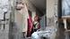 Palestinians look out of a heavily damaged apartment Palestinians look out of a heavily damaged apartment