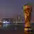 Katar | Replika des FIFA WM Pokal vor der Skyline von Doha 