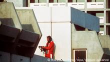 Ein bewaffneter Polizeibeamter im Trainingsanzug in Stellung am 05.09.1972 im Olympischen Dorf in München. Arabische Terroristen des Kommandos Schwarzer September überfallen das Quartier der israelischen Mannschaft. Sie erschießen zwei Israelis und nehmen weitere neun als Geiseln, die später in der Nacht zum 6. September bei der fehlgeschlagenen Befreiungsaktion auf dem Militärflughafen in Fürstenfeldbruck zusammen mit fünf Terroristen und einem Münchner Polizisten ums Leben kommen. [dpabilderarchiv]