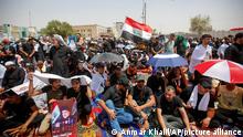 Supporters of the Shiite cleric Muqtada al-Sadr hold prayer near the parliament building in Baghdad, Iraq, Friday, Aug. 12, 2022. Al-Sadr's supporters continue their sit-in outside the parliament to demand early elections. The photo show Muqtada al-Sadr. (AP Photo/Anmar Khalil)