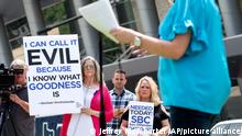 Carol Shelton, left, and Cheryl Summers, center, hold signs as they listen to abuse victim advocate Mary DeMuth speak during a rally protesting the Southern Baptist Convention's treatment of women on Tuesday, June 12, 2018, outside the convention's annual meeting at the Kay Bailey Hutchison Convention Center in Dallas. (AP Photo/Jeffrey McWhorter)