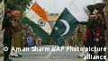 Both Indian and Pakistani soldiers lower their respective national flags during a flag off ceremony at India and Pakistan joint border check post, Wagah
