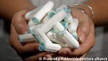 A woman holds up a bunch of tampons