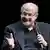 Salman Rushdie holding a microphone.