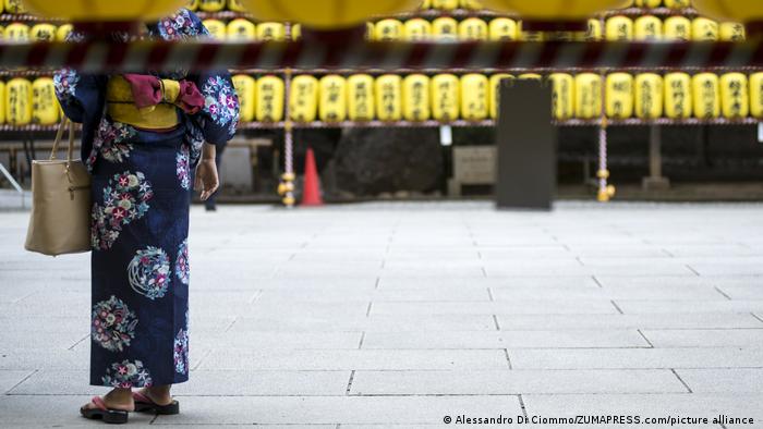 Mujer viste un kimono, un vestido tradicional japonés, en una calle de Tokio.