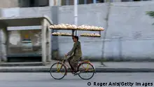 9.5.2022, Kairo, Ägypen, CAIRO, EGYPT - MAY 9: A worker on a bike delivers Egyptian traditional 'Baladi' bread from a bakery in Sayeda Zeinab neighborhood to bread stands on May 9, 2022 in Cairo, Egypt. Last month, Egypt introduced price controls on commercially sold bread in response to the rising price of wheat. Egypt imports 80% of its wheat supply from Russia and Ukraine, whose production and export have been disrupted by the invasion. (Photo by Roger Anis/Getty Images)