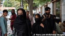 KABUL, AFGHANISTAN - AUGUST 14: Women cover their faces when walking down a street on August 14, 2022 in Kabul, Afghanistan. The collapse of the economy and the freezing of Afghan and donor funds after the Taliban takeover of the country in August 2021 created a humanitarian crisis. Most art, culture and pastimes have been banned. The female population have also had to quit jobs and young girls after the age of 12 can no longer go to school or complete further education. (Photo by Nava Jamshidi/Getty Images)