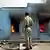 Policeman stands in front of burning Muslim shops in Ahmedabad, February 2002