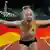 Leichtathletin Gina Lückenkemper jubelt nach ihrem Sieg 100 Meter bei der EM in München mit einer deutschen Fahne in Händen