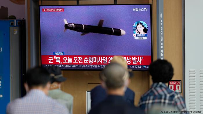 People at the Seoul Railway Station watch a television screen showing a file image of a North Korean missile launch 