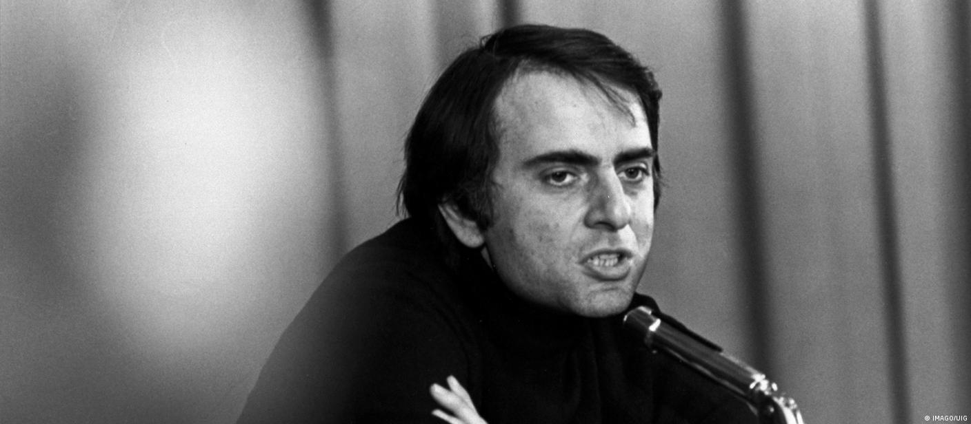 O astrônomo, cientista planetário, cosmólogo, astrofísico, astrobiólogo e promotor da ciência Carl Sagan fala a um microfone