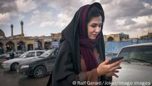 Iran, junge Frau mit ihrem Smartphone Eine junge Frau geht über einen Parkplatz und schaut dabei auf ihr Smartphone. Isfahan, Provinz Isfahan, Islamische Republik Iran, 16.01.2019. *** Iran, young woman with her smartphone A young woman walks across a parking lot and looks at her smartphone Isfahan, Isfahan province, Islamic Republic of Iran, 16 01 2019 Copyright: JOKER/RalfxGerard JOKER190116422951