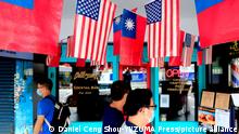  People walk past US-Taiwan flags which are hung outside an eatery in Taipei.