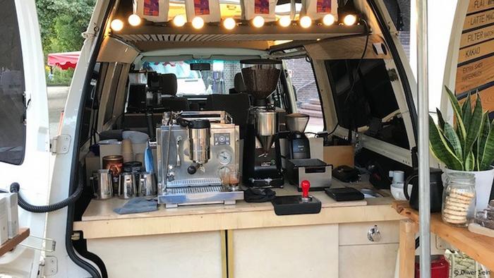 L'arrière ouvert d'un camping-car avec une machine à café et un moulin