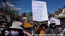 A coca grower holds a sign with the message that reads in Spanish Adepcoca is respected damn it, illegal market dies, during a march towards police to ask them to release detained coca farmers, during the sixth day of protests in La Paz, Bolivia, Wednesday, Aug. 10, 2022. Anti-government coca farmers are protesting against a parallel coca leaf market in La Paz. ADEPCOCA is the Spanish acronym for Asociación Departamental de Productores de Coca or Departmental Association of Coca Farmers. (AP Photo/Juan Karita)
