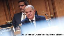 Bundeskanzler Olaf Scholz (SPD) sitzt auf seinem Platz auf der Senatsbank vor Beginn einer Sitzung des Parlamentarischen Untersuchungsausschusses „Cum-Ex“ im Plenarsaal der Hamburgischen Bürgerschaft im Rathaus. Scholz sagt erneut vor dem Ausschuss aus. Im Hintergrund sitzt Regierungssprecher Steffen Hebestreit.