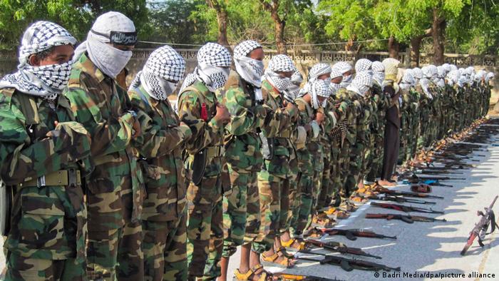 Somalia's al-Shabab fighters in camouflage clothes conduct Muslim prayers outside.