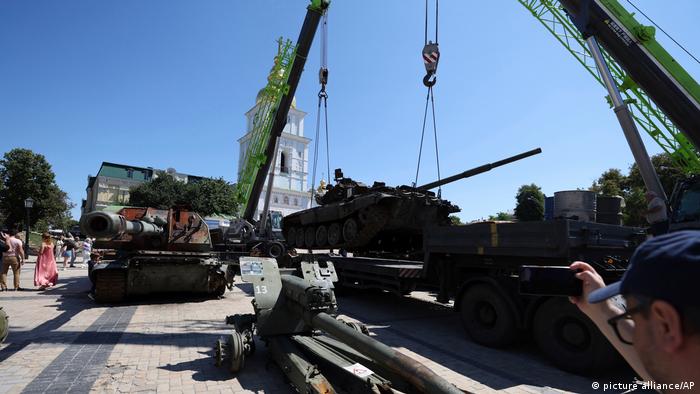 Construction equipment moves tanks in front of a monastery in Kiev