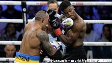 Britain's Anthony Joshua, right, takes a blow from Ukraine's Oleksandr Usyk during their world heavyweight title fight at King Abdullah Sports City in Jeddah, Saudi Arabia, Sunday, Aug. 21, 2022. (AP Photo/Hassan Ammar)