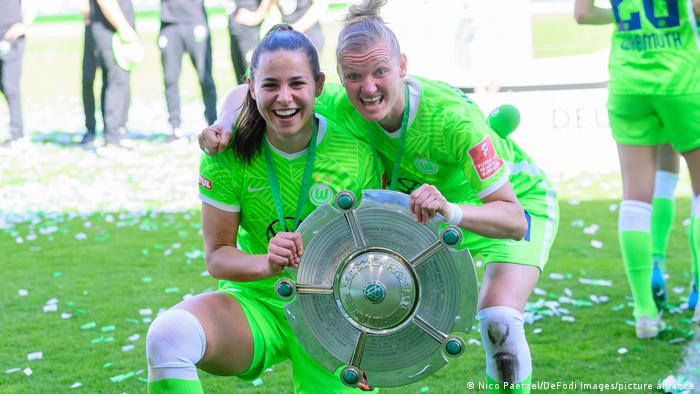 Die Wolfsburger Lena Oberdorf und Alexandra Popp halten den Meisterpokal der Bundesliga.