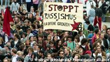 Protestors walk in front of a banner, reading Stop Racism, in Rostock's Lichtenhagen district, August 29, 1992. About 10,000 people demonstrated against the violence against foreigners and growing racism in Germany, after Neo Nazis attacked an asylum shelter in Lichtenhagen a week ago. (AP Photo/Wolfram Steinberg)