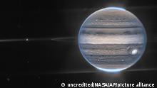This image provided by NASA shows a false color composite image of Jupiter obtained by the James Webb Space Telescope on July 27, 2022. The planet’s rings and some of its small satellites are visible along with background galaxies. (NASA via AP)