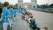 Women wearing blue dresses and white boots stand in line; children are sitting in a line in front of them, ahead of the opening of the OIympic Games in 1972. Women wearing blue dresses and white boots stand in line; children are sitting in a line in front of them, ahead of the opening of the OIympic Games in 1972.