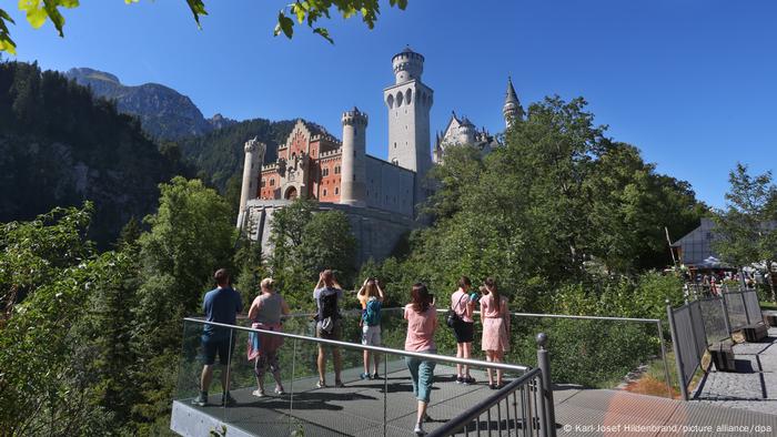 Turistas en una plataforma de observación frente al castillo de Neuschwanstein, Baviera