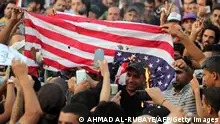 Supporters of Iraqi Shiite cleric Moqtada al-Sadr burn a US flag during a demonstration in Baghdad's Tahrir Square on September 16, 2016, calling for governmental reforms.
Iraq's government is mired in corruption, struggles to provide basic services, and positions have for years been shared out based on political and sectarian quotas that protesters have demanded be scrapped. / AFP / AHMAD AL-RUBAYE (Photo credit should read AHMAD AL-RUBAYE/AFP via Getty Images)