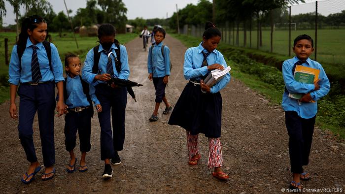 Parwati Sunar goes to school with her son and other classmates.