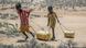 Young girls pull containers of water as they return from a well in northern Kenya Young girls pull containers of water as they return from a well in northern Kenya