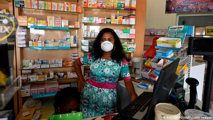 A pharmacy worker wears a mask
