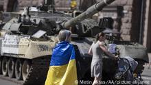 Dos mujeres en las calles de Kiev, una cubierta con una bandera ucraniana.