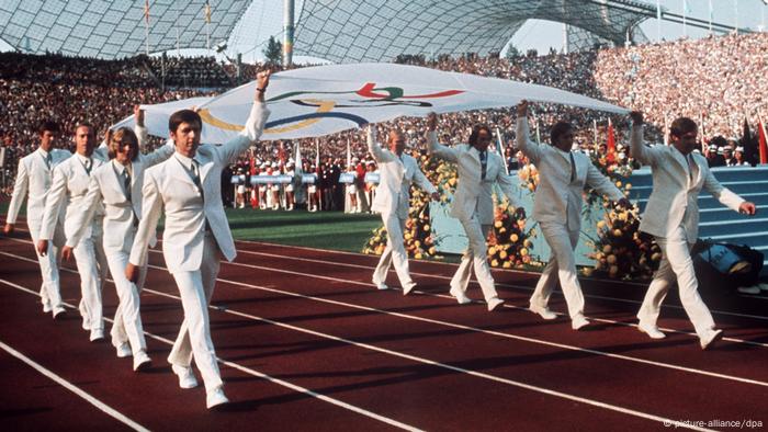 The German rowing team marching into the Munich stadium carrying the Olympic flag The German rowing team marching into the Munich stadium carrying the Olympic flag
