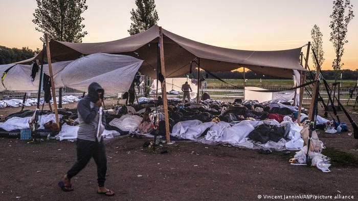 People are seen sleeping in makeshift camps outside an asylum center in The Netherlands
