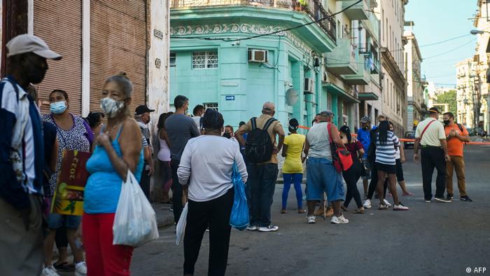 Personas forman fila para comprar alimentos en La Habana.