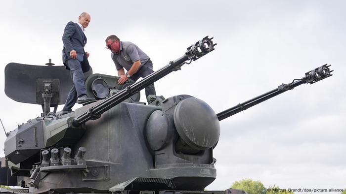 Bundeskanzler Olaf Scholz klettert auf einen Gepard Panzer.