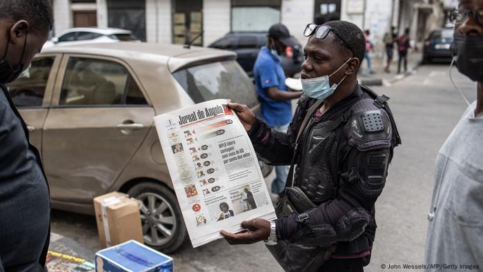 Mann zeigt Zeitung mit Wahlergebnis