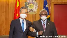 FILE - In this photo released by Xinhua News Agency, Solomon Islands Prime Minister Manasseh Sogavare, right, locks arms with visiting Chinese Foreign Minister Wang Yi in Honiara, Solomon Islands on May 26, 2022. A U.S. coast guard cutter conducting patrols as part of an international mission to prevent illegal fishing was recently unable to get clearance for a scheduled port call in the Solomon Islands, according to reports, an incident that comes amid growing concerns of Chinese influence on the Pacific nation. (Xinhua via AP, File)