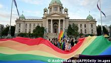 People hold a huge rainbow flag in front of the National Assembly building, during the Belgrade Pride march, on September 18, 2021. (Photo by Andrej ISAKOVIC / AFP) (Photo by ANDREJ ISAKOVIC/AFP via Getty Images)