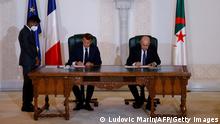 French President Emmanuel Macron (L) and Algeria's President Abdelmadjid Tebboune (R) attend a signing ceremony in the pavilion of honour at Algiers airport, in Algiers, on August 27, 2022. - Emmanuel Macron is on a three-day visit to Algeria aimed at mending ties with the former French colony, which this year marks its 60th anniversary of independence. (Photo by Ludovic MARIN / AFP) (Photo by LUDOVIC MARIN/AFP via Getty Images)