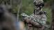 Soldado ucraniano em traje camuflado e com o rosto encoberto segura um fuzil Soldado ucraniano em traje camuflado e com o rosto encoberto segura um fuzil