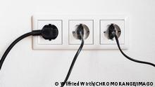 Drei schwarze Stecker in einer weiﬂen dreifach Steckdose *** Three black plugs in a white triple socket 1100402278