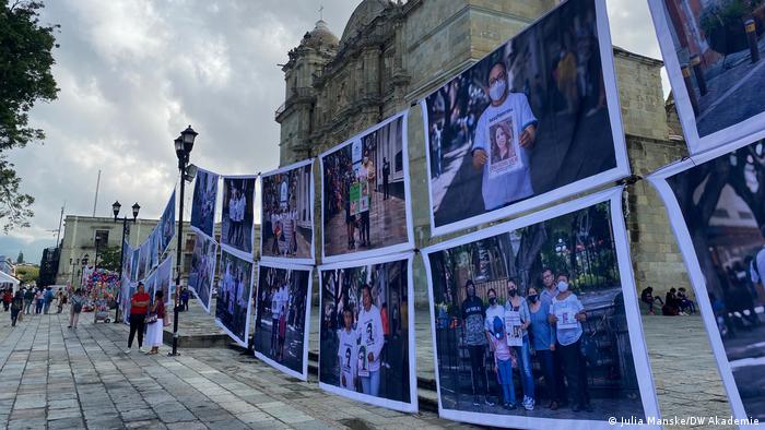 The DW Akademie- suported photo project hangs in a busy square in front of a church.