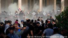 Iraqi security forces fire tear gas on the followers of Shiite cleric Muqtada al-Sadr inside the government Palace, Baghdad, Iraq, Monday, Aug. 29, 2022. Al-Sadr, a hugely influential Shiite cleric announced he will resign from Iraqi politics and his angry followers stormed the government palace in response. The chaos Monday sparked fears that violence could erupt in a country already beset by its worst political crisis in years. (AP Photo/Hadi Mizban)