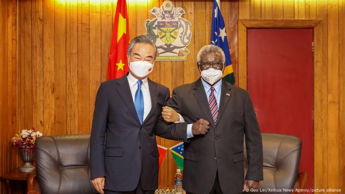 Chinese Foreign Minister Wang linked arms with Solomon's Premier Sogavere