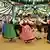 Frauen und Männer einer bayerischen Volkstanzgruppe in Tracht, die einen Kreis von tanzenden Paaren bilden